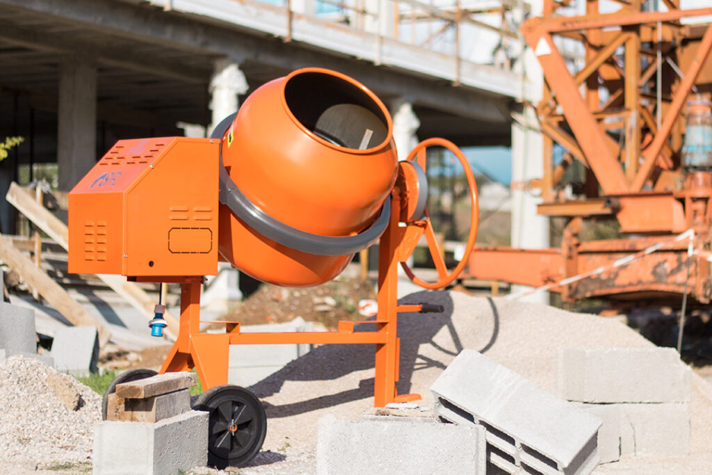 An orange SIRL concrete mixer on the sit of a construction project.