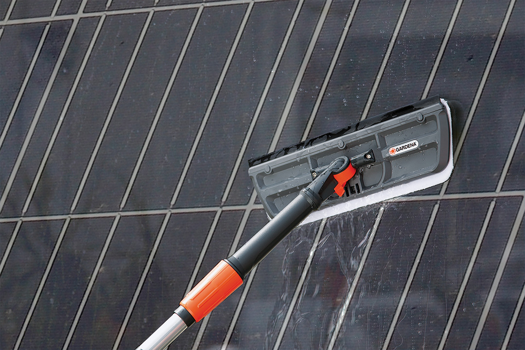 The GARDENA Cleansystem washing a solar panel.