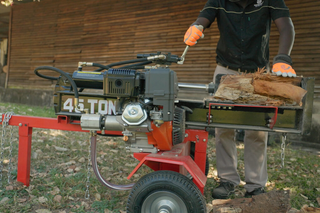 A red Hunter log splitter with a large log on the deck.