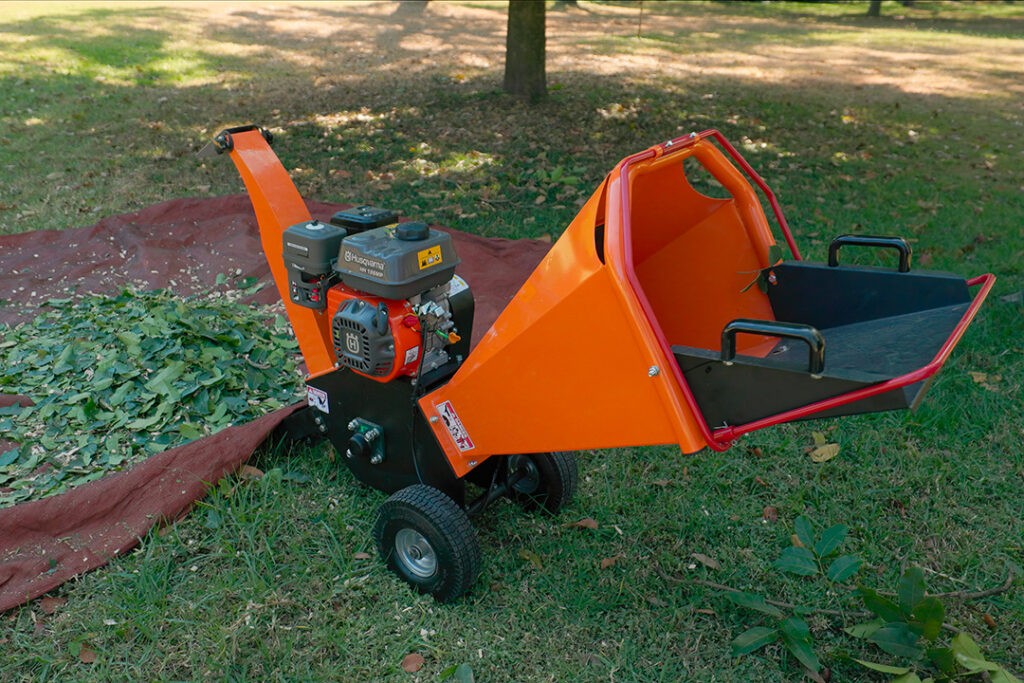 An orange Hunter wood chipper with mulch around the base.