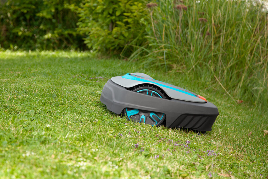 A Gardena SILENO minimo 1250 robotic lawnmower on a green lawn.