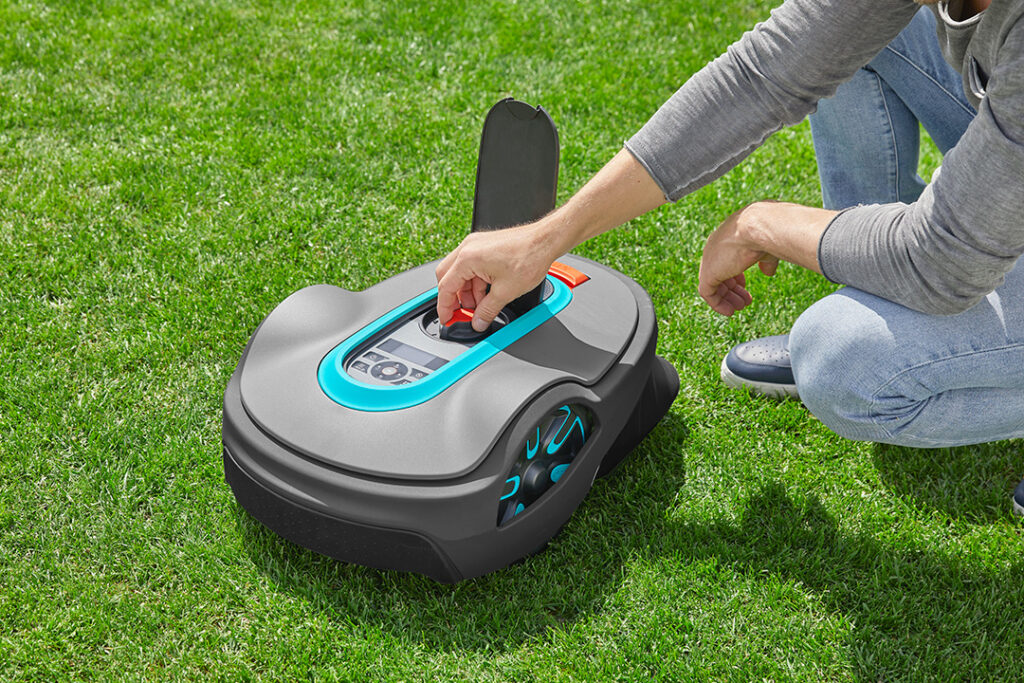 A man changes the settings on his GARDENA SILENO life 1250 robotic mower. 